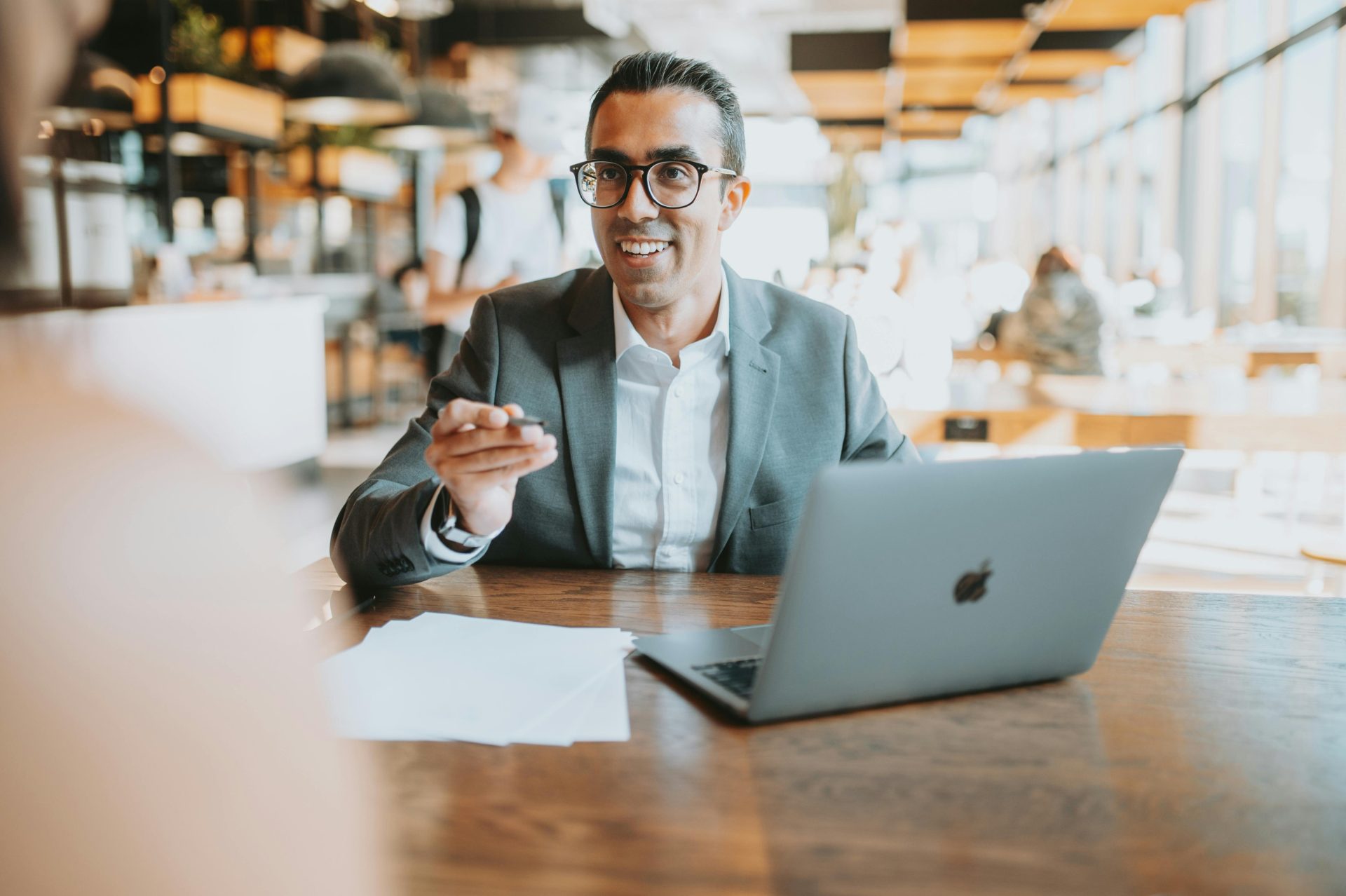 Professional man in suit using laptop in a modern cafe setting. Ideal for business themes.