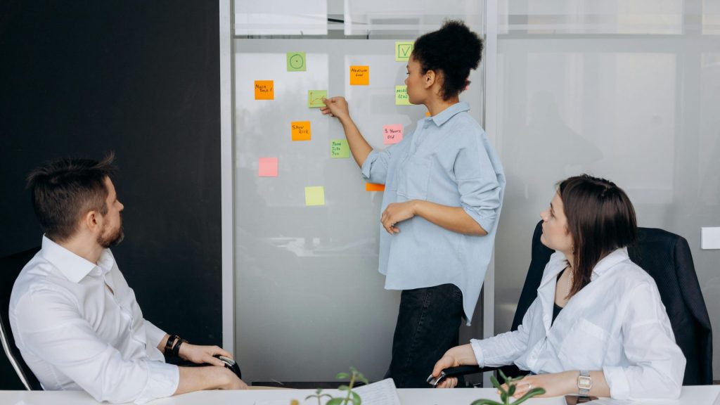 Business team collaborating and brainstorming in a meeting room with sticky notes.